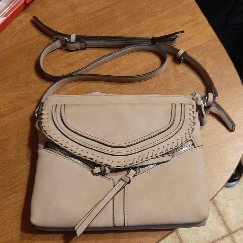 Tan purse with black accents along edges.